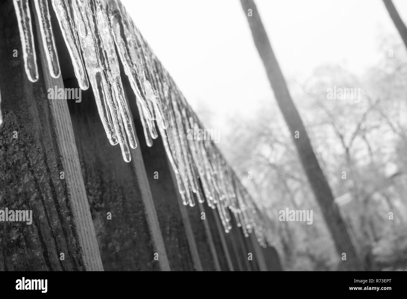 Eiszapfen hängen von einer Veranda. Stockfoto