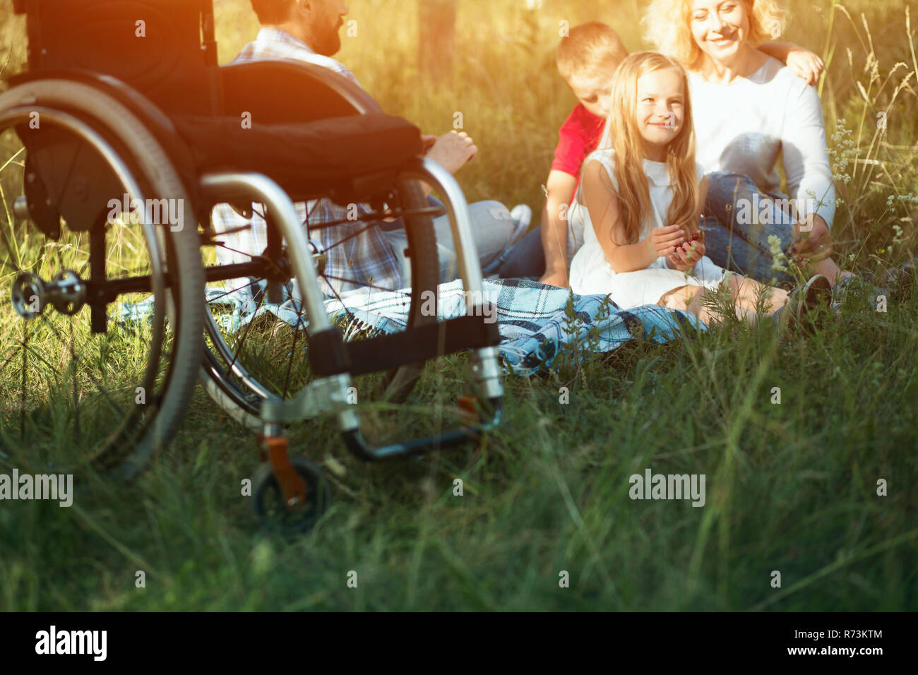 Fokus auf emply Rollstuhl auf den Vordergrund während happy family Rest auf dem Hintergrund Stockfoto