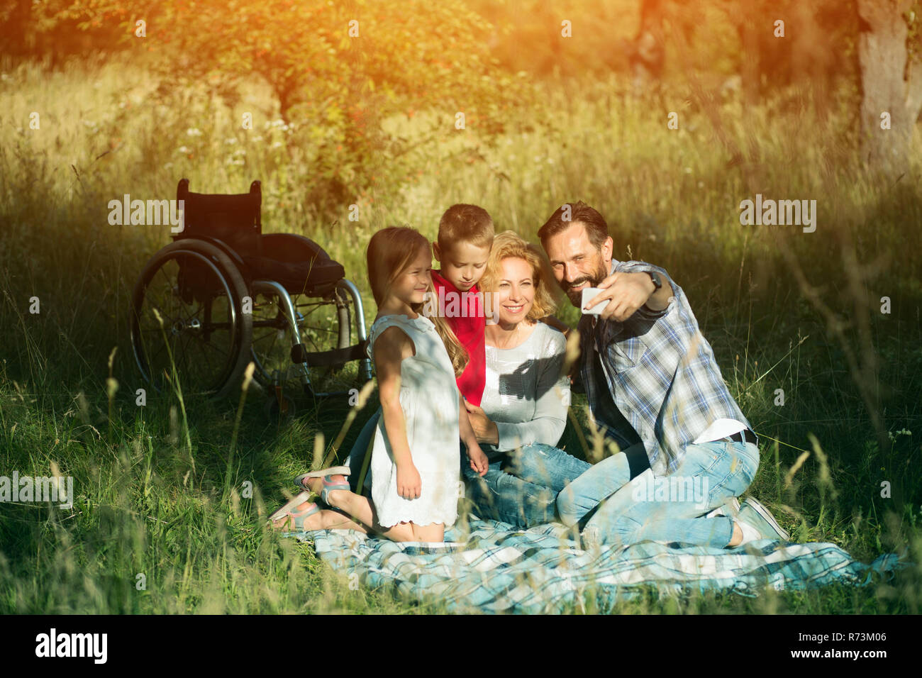 Glückliche Familie selfie auf dem Picknick im Park. Paraplegic Stockfoto