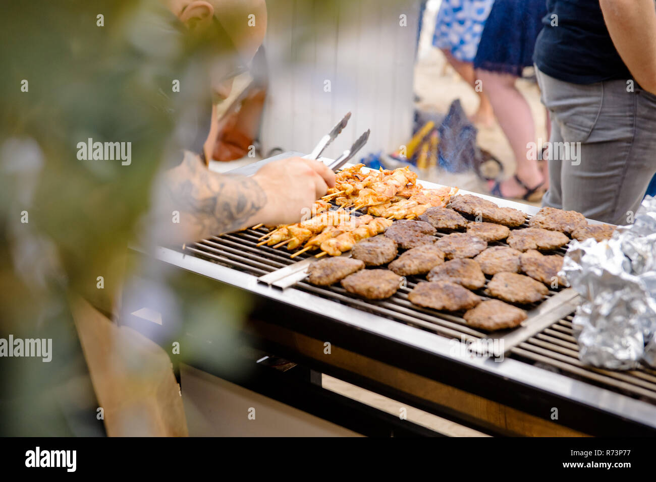 Fleisch auf dem Grill ein Koch bei einem Sommerfest im Garten vorbereitet  Stockfotografie - Alamy