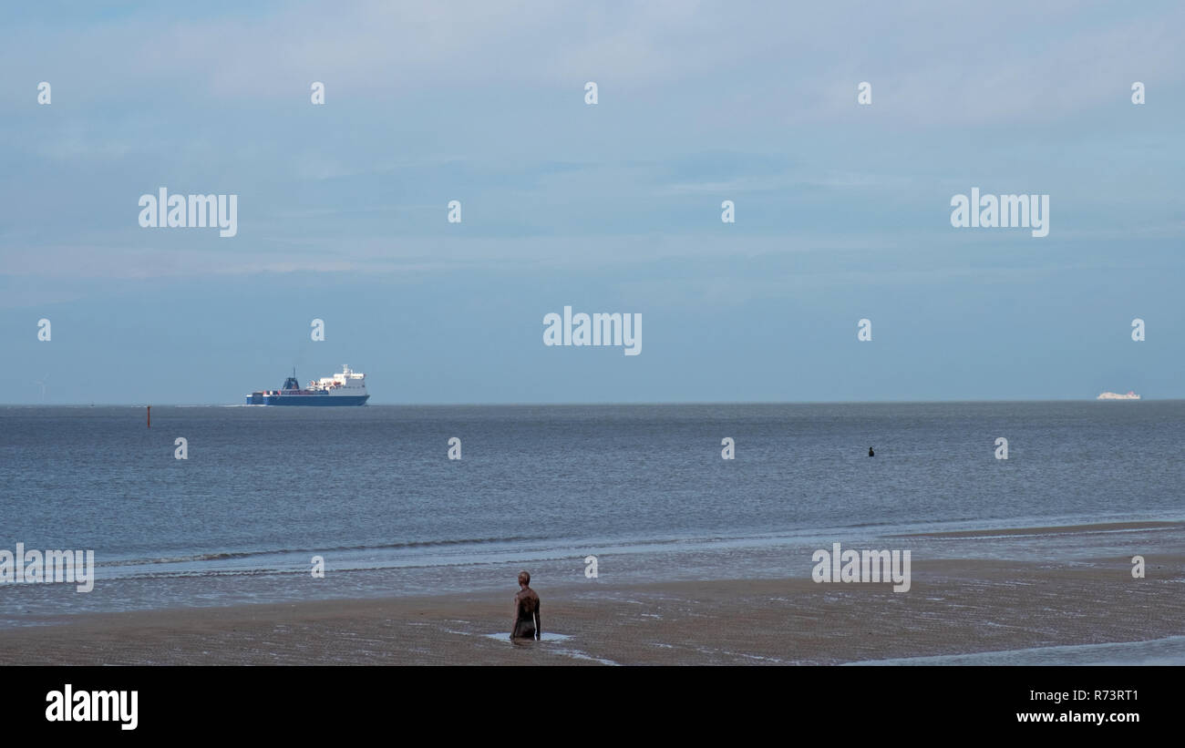 Crosby, England - November 6, 2018: Schiff am Strand im Norden von Liverpool, welche Hosts eine Kunstinstallation von Anthony Gormley als einen anderen Ort bekannt Stockfoto