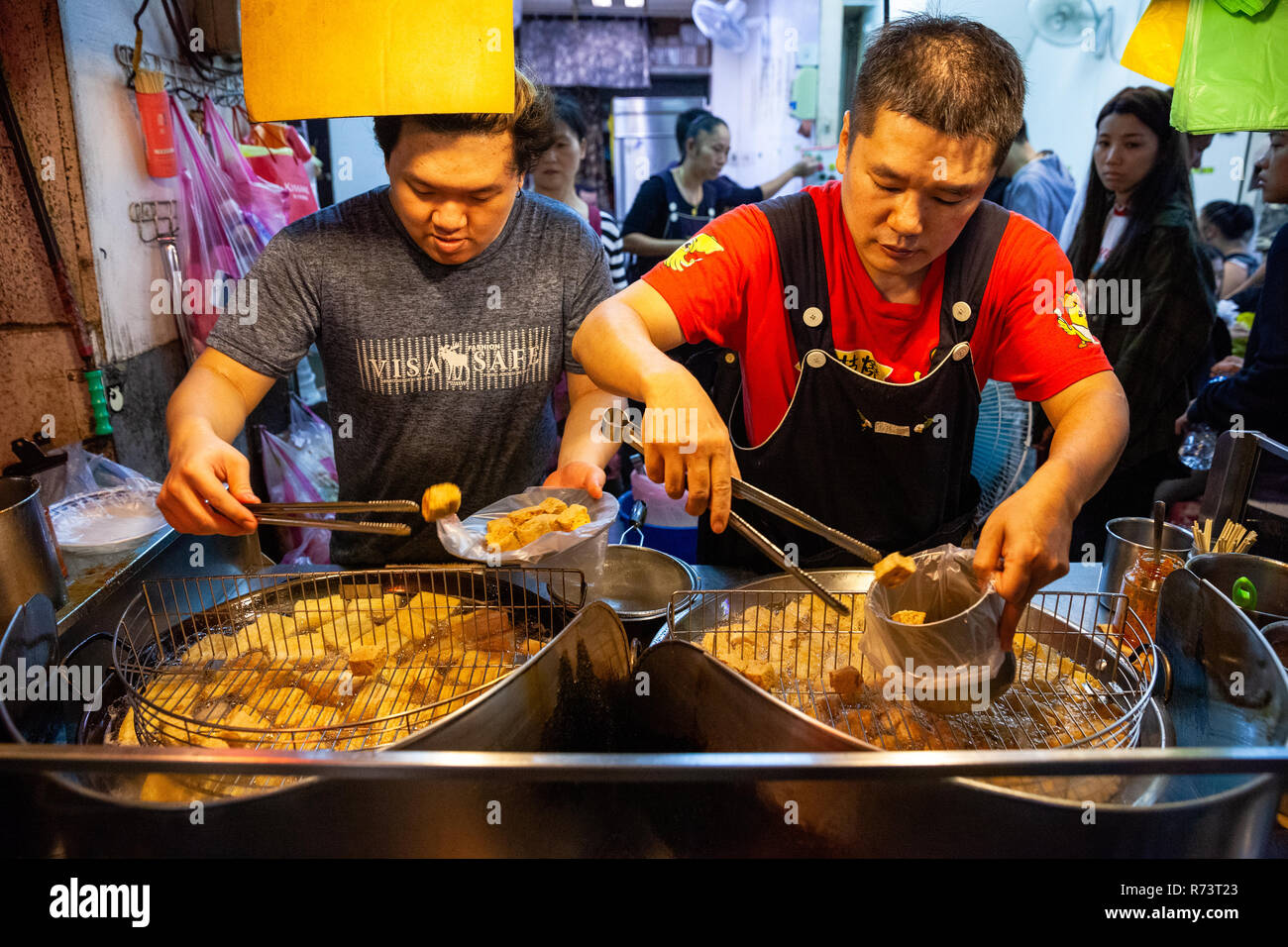 JIUFEN, TAIWAN - 6. NOVEMBER: Zwei Männer kochen stinky Tofu auf dem Nachtmarkt von Jiufen am 6. November 2018 in Jiufen, Taiawan. Stockfoto