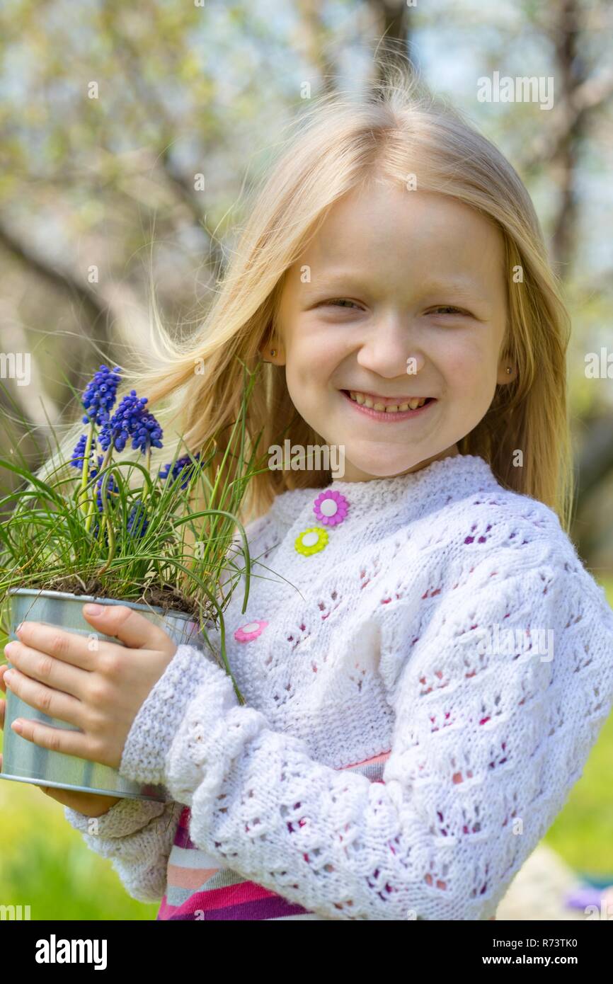 Lächelnde Mädchen mit Blumen Hyazinthen im Topf Stockfoto