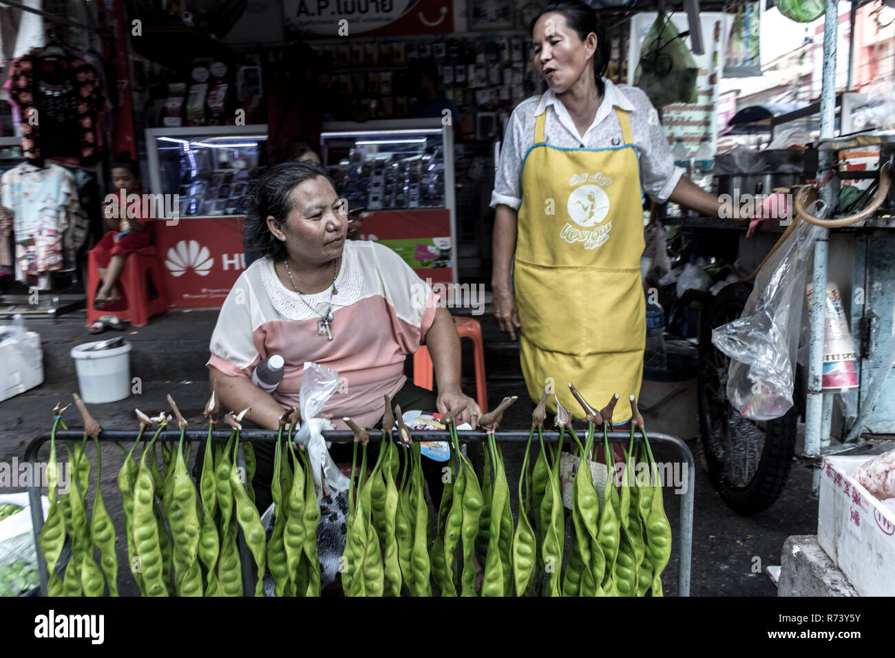 Zwei Thailändische Frauen plaudern über die Tage der Handel bei Tag markt Phuket's Altstadt. Stockfoto