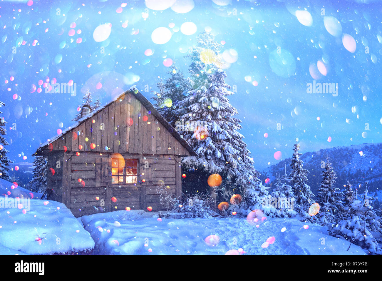 Fantastische Szene mit schneebedeckten Haus am Wald. Licht im kleinen Fenster. Weihnachten Postkarte Collage. DOF bokeh Licht postprocessing Effekt Stockfoto