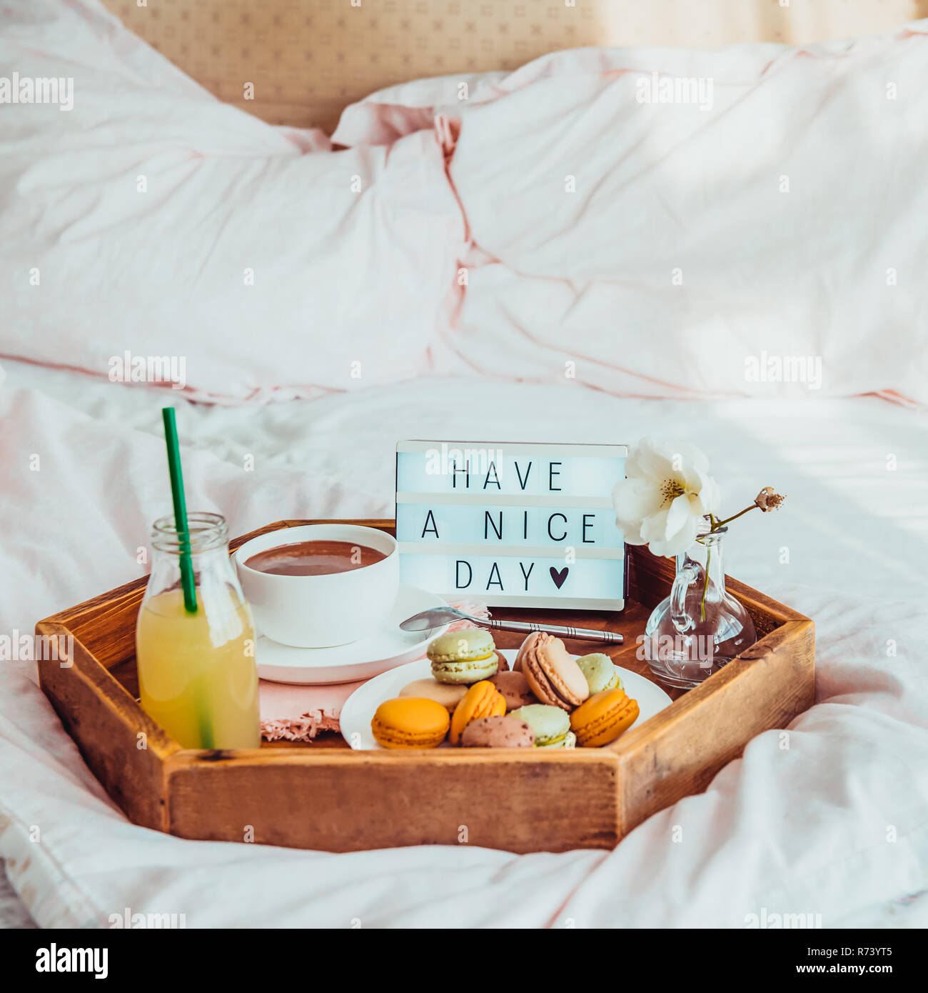 Frühstück im Bett, mit Ihnen einen schönen Tag Text auf beleuchtet. Tasse  Kaffee, Saft, Makronen, Blumen in Vase auf Holz- fach Guten morgen  Stimmung. Krankenhaus Stockfotografie - Alamy