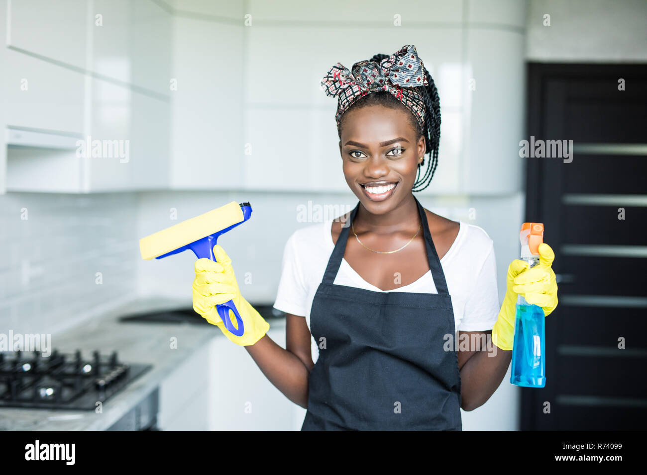 Lächelnd afrikanische Frau reinigen Sie das Fenster mit der rag Stockfoto