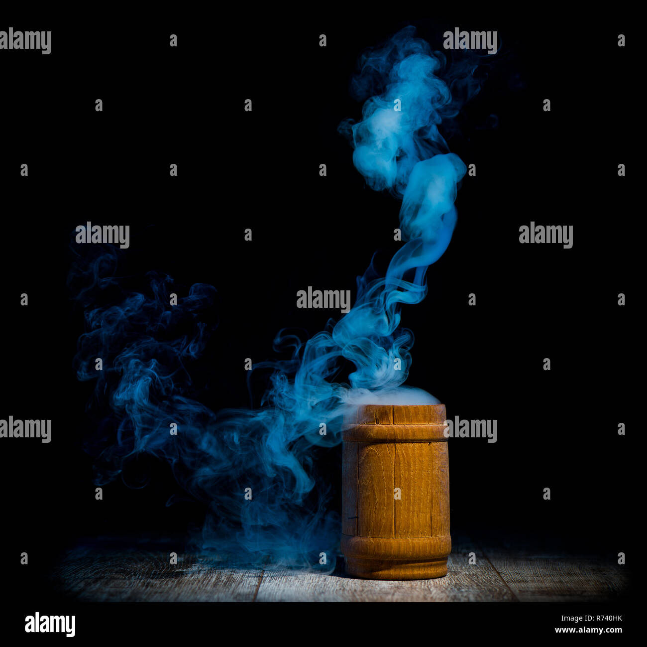 Blauer Rauch aus Holz auf dunklem Hintergrund isoliert Stockfoto