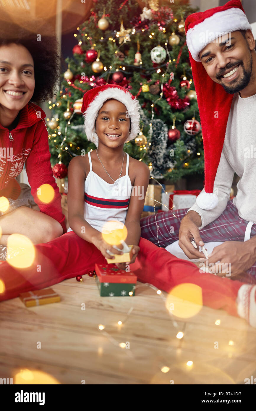 Portrait von lächelnden Familie den Austausch von Geschenken vor Weihnachtsbaum Stockfoto