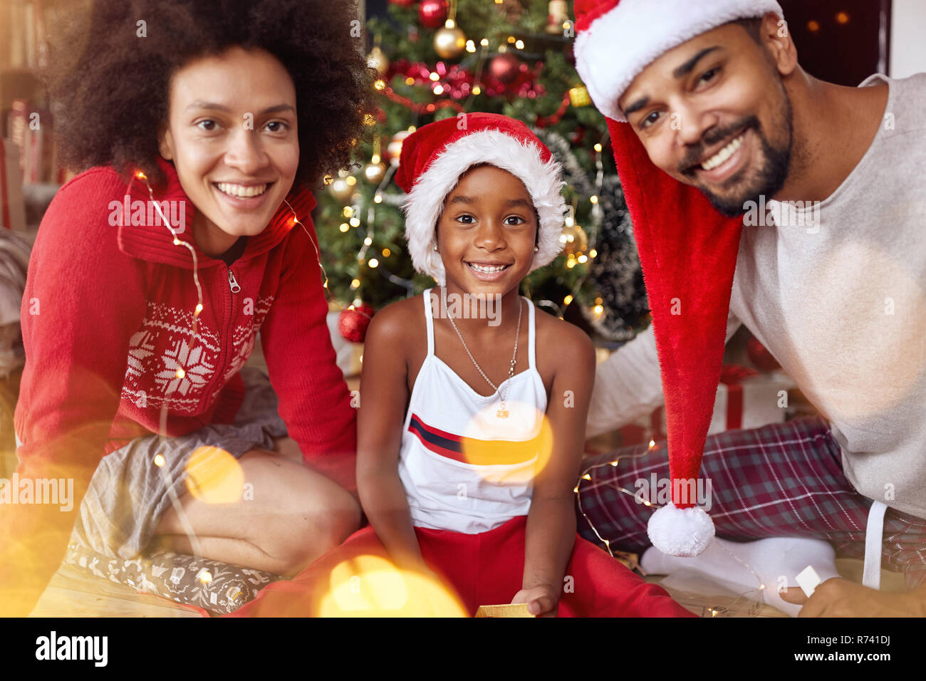 Portrait von lächelnden Afrikanische amerikanische Familie vor dem Weihnachtsbaum Stockfoto