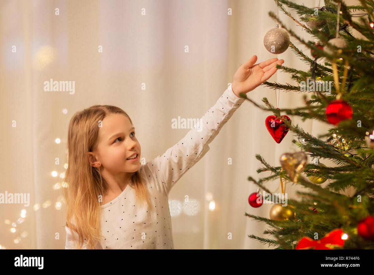 Glückliches Mädchen im roten Kleid Dekoration Weihnachtsbaum Stockfoto