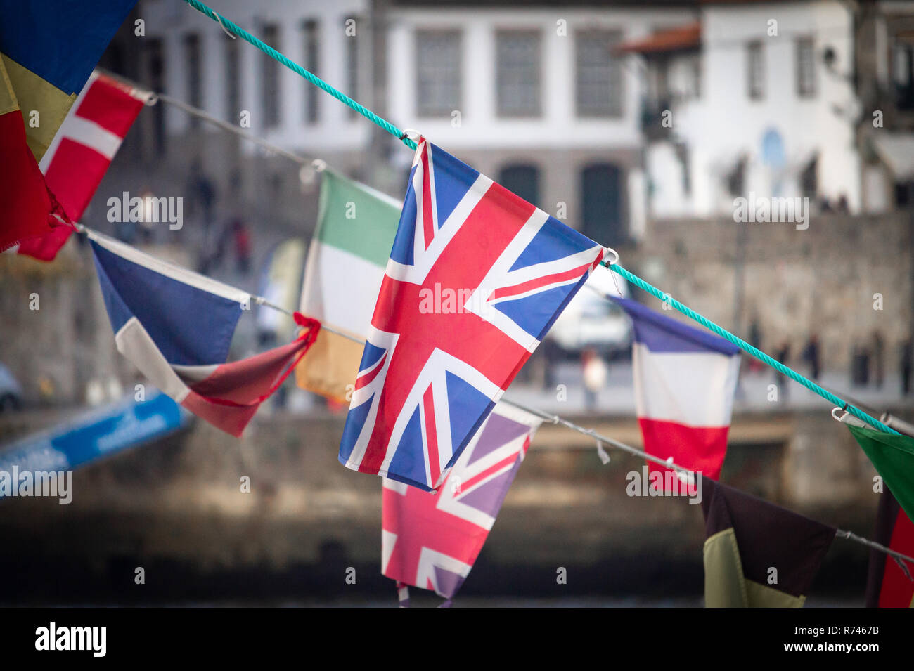 Eine Flagge des Vereinigten Königreichs Wellen inmitten von anderen nationalen Flaggen (Irland, Frankreich, Dänemark), gegen eine alte Stadt Hintergrund. Stockfoto