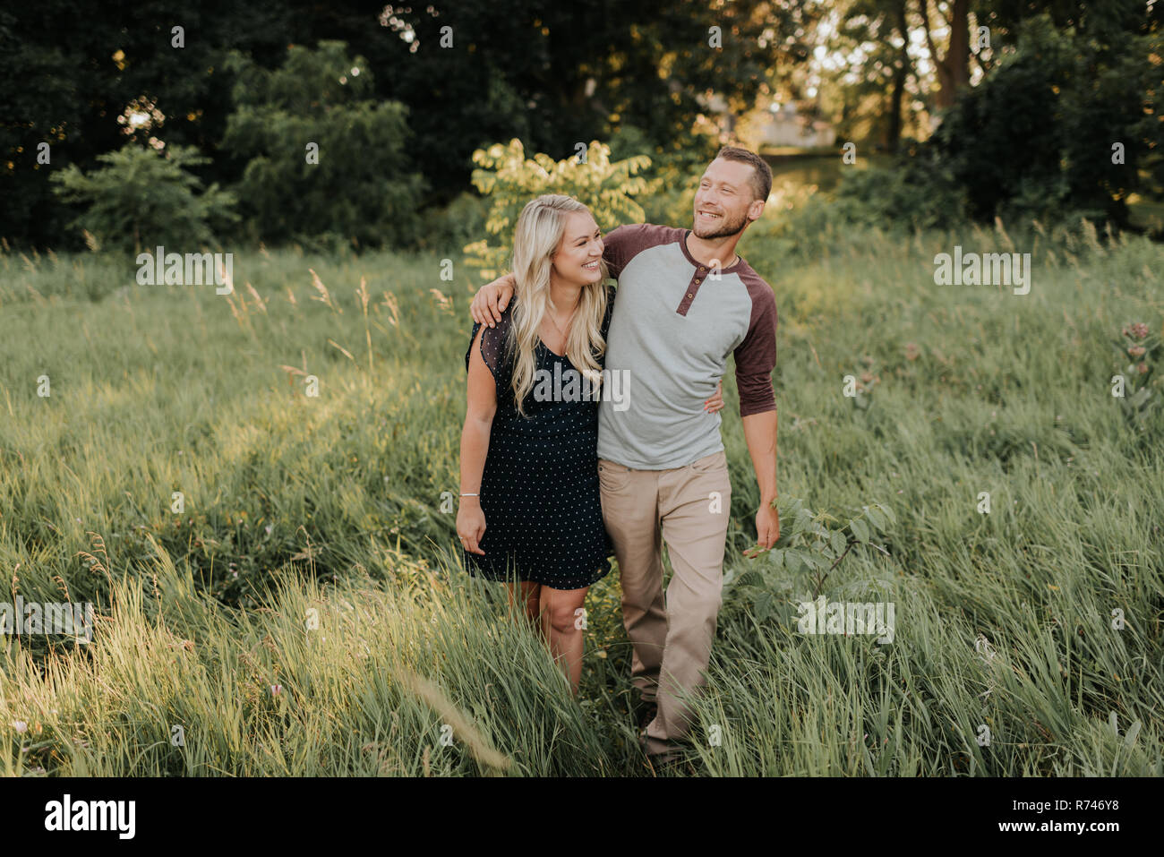 Romantische junge Frau und Freund im Bereich der langen Gras spazieren Stockfoto