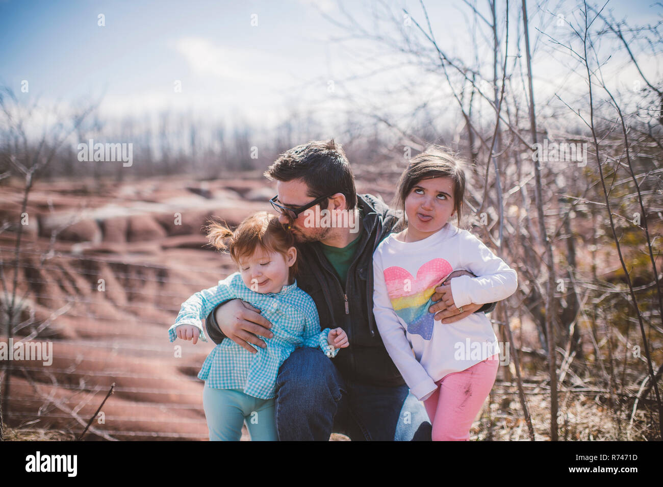 Weibliche Toddler mit Schwester und Vater posing und Grimassen Stockfoto