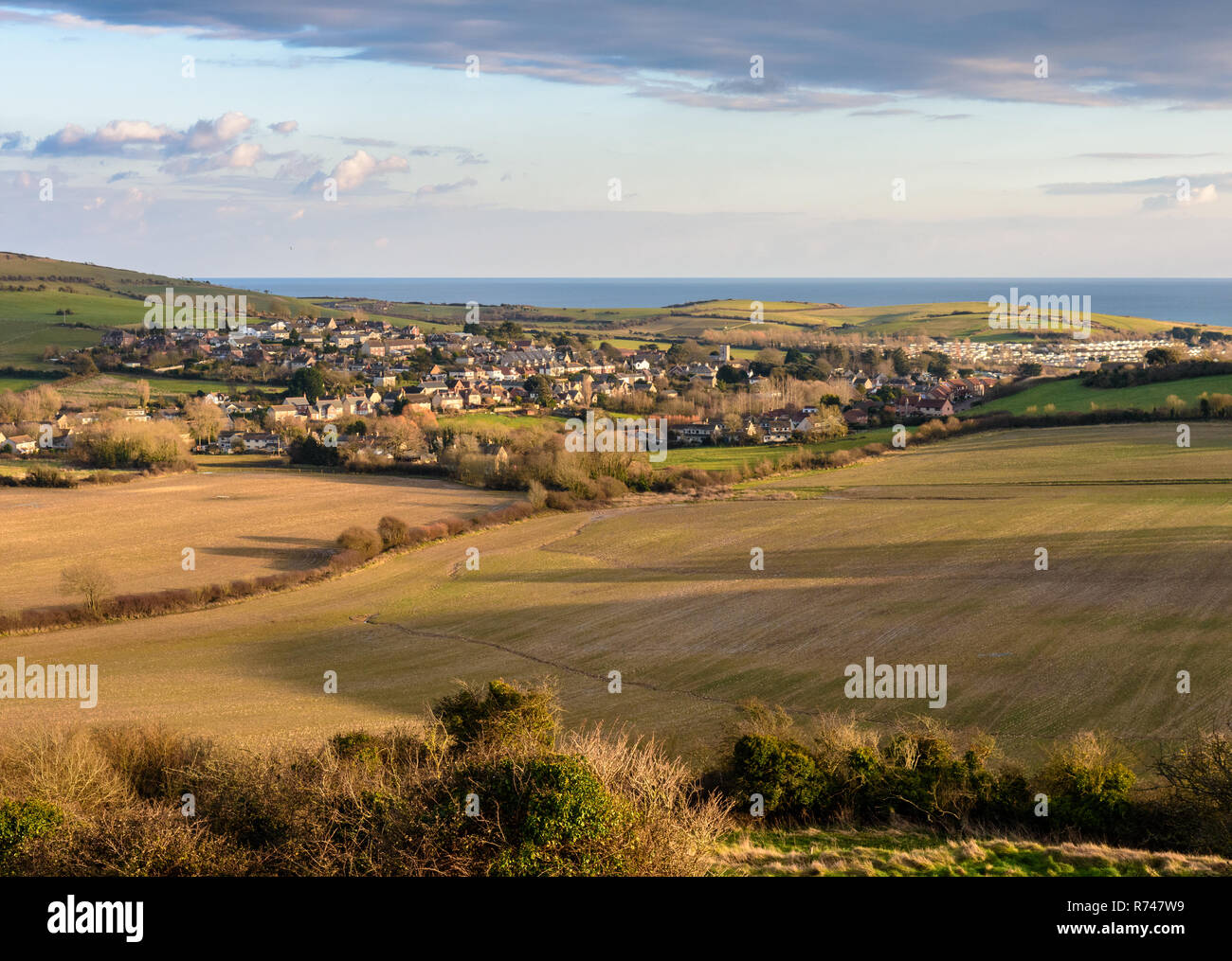 Häuser des Dorfes Osmington sind unter den Feldern in einem Tal in der Dorset Downs Hügeln, neben Jurassic Coast, dem Englischen Kanal. Stockfoto