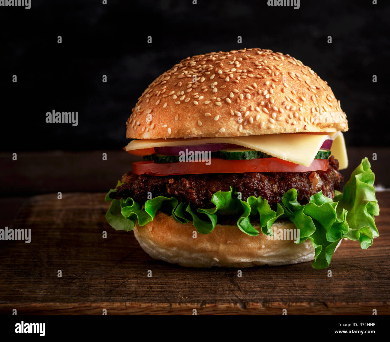 Frische, hausgemachte Burger mit Salat, Käse, Zwiebeln und Tomaten Stockfoto