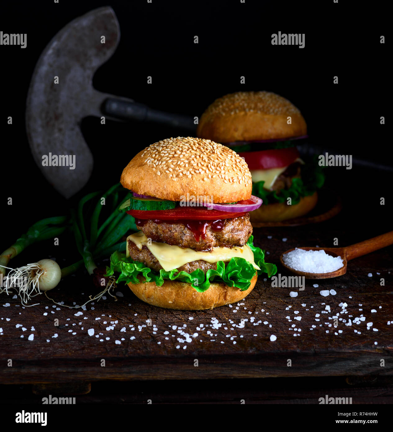 Hausgemachte Burger mit Salat, Käse, Zwiebeln und Tomaten Stockfoto