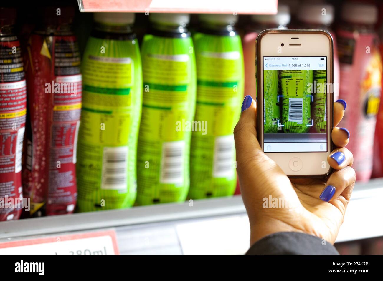 Shopping mit einem smart phone Barcodes der Konsumgüter in einem Supermarkt zu scannen Stockfoto