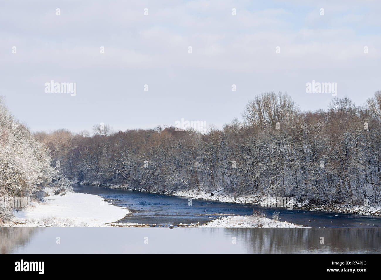 Blick auf verschneite Bäume und einen Fluss an einem kalten Tag im Winter Ruhe. Stockfoto
