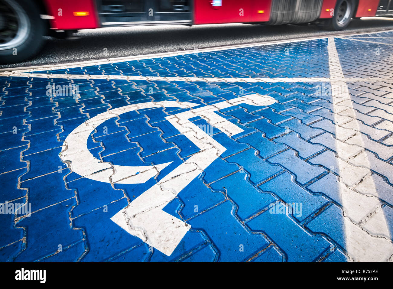 Behinderte blau Parkplatz Schild in Warschau, Polen, Rot verschwommen Bus im Hintergrund Stockfoto