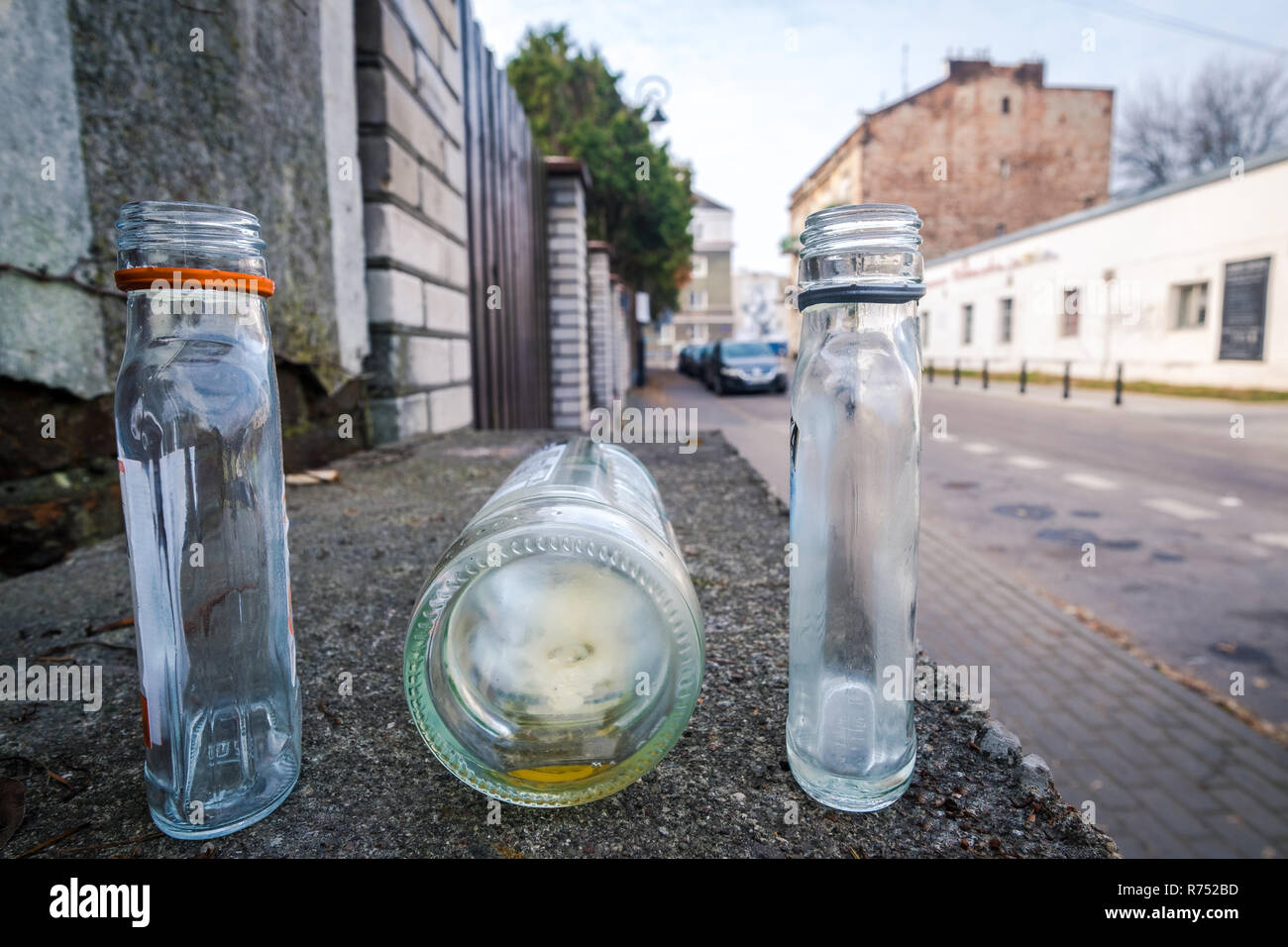 Drei verlassene leere Flaschen auf der Straße von Warschau, Polen, unscharfen Hintergrund, keine Menschen. Stockfoto