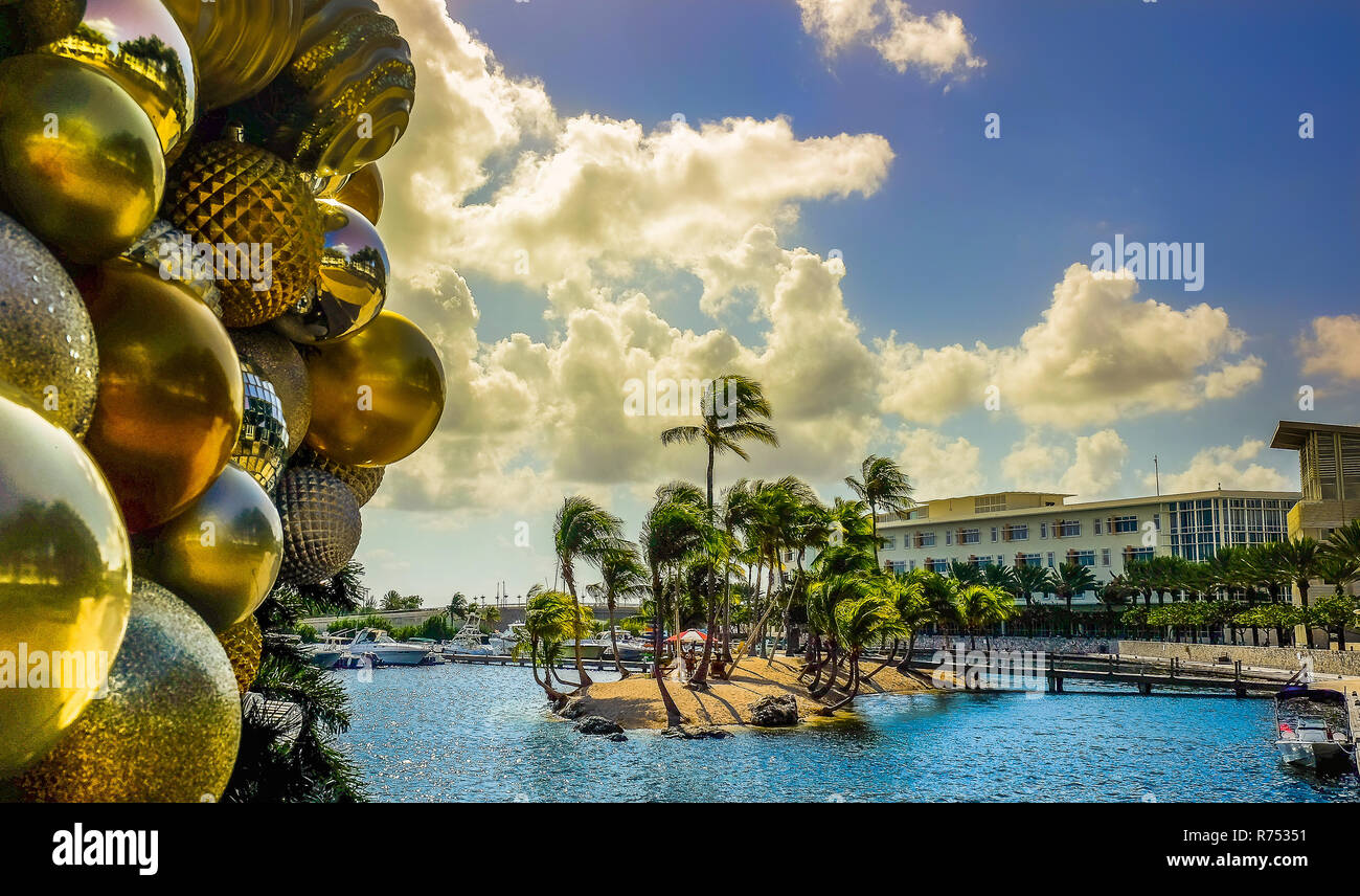 Nahaufnahme von Christbaumkugeln mit im Hintergrund die Insel in Camana Bay bei Sonnenuntergang, Grand Cayman, Cayman Islands Stockfoto