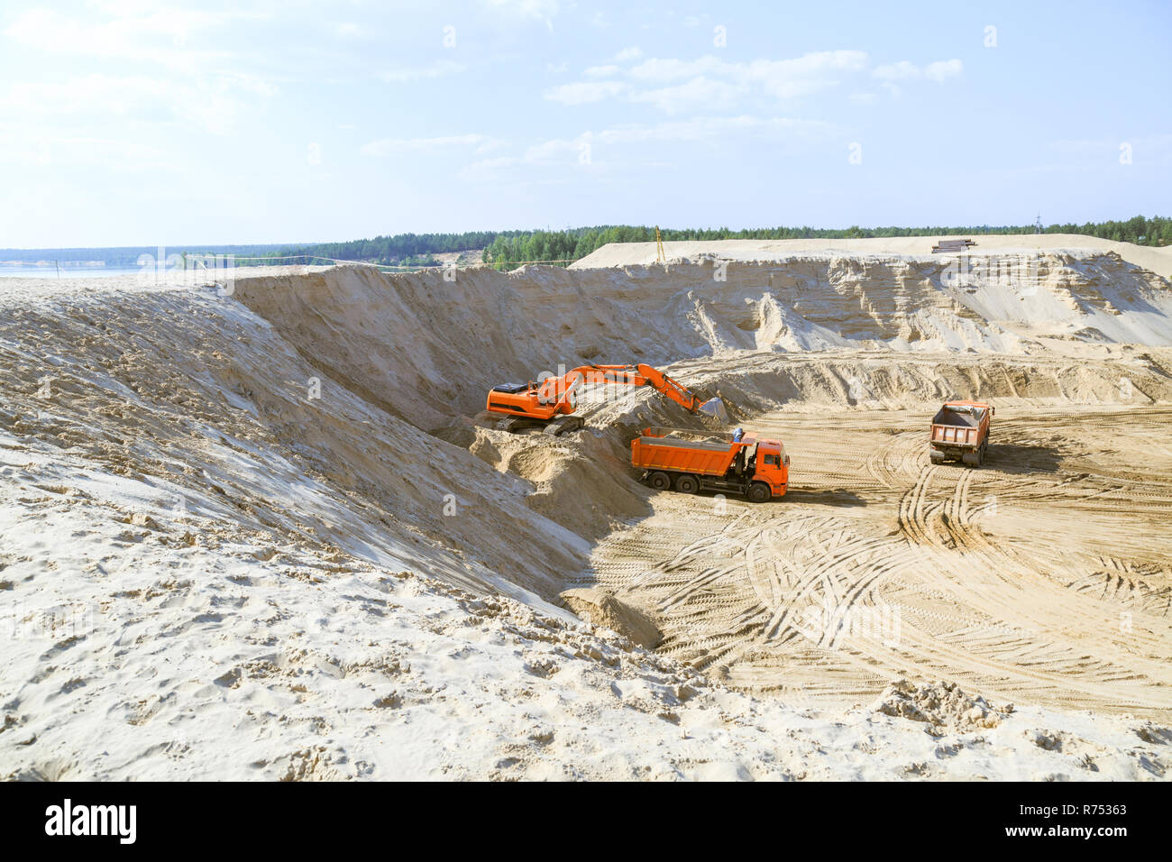 Arbeit der Bagger und Lkw an einer sand Steinbruch. Bagger laden Sand in einen Dump Truck. Stockfoto