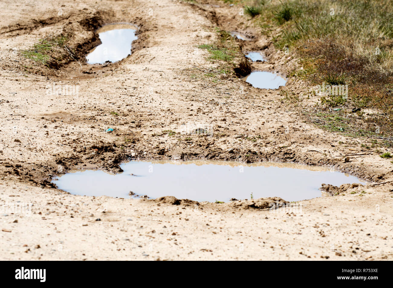 Wasser gefüllten Spurrillen im Schlamm, der aussieht wie ein Smiley. Stockfoto