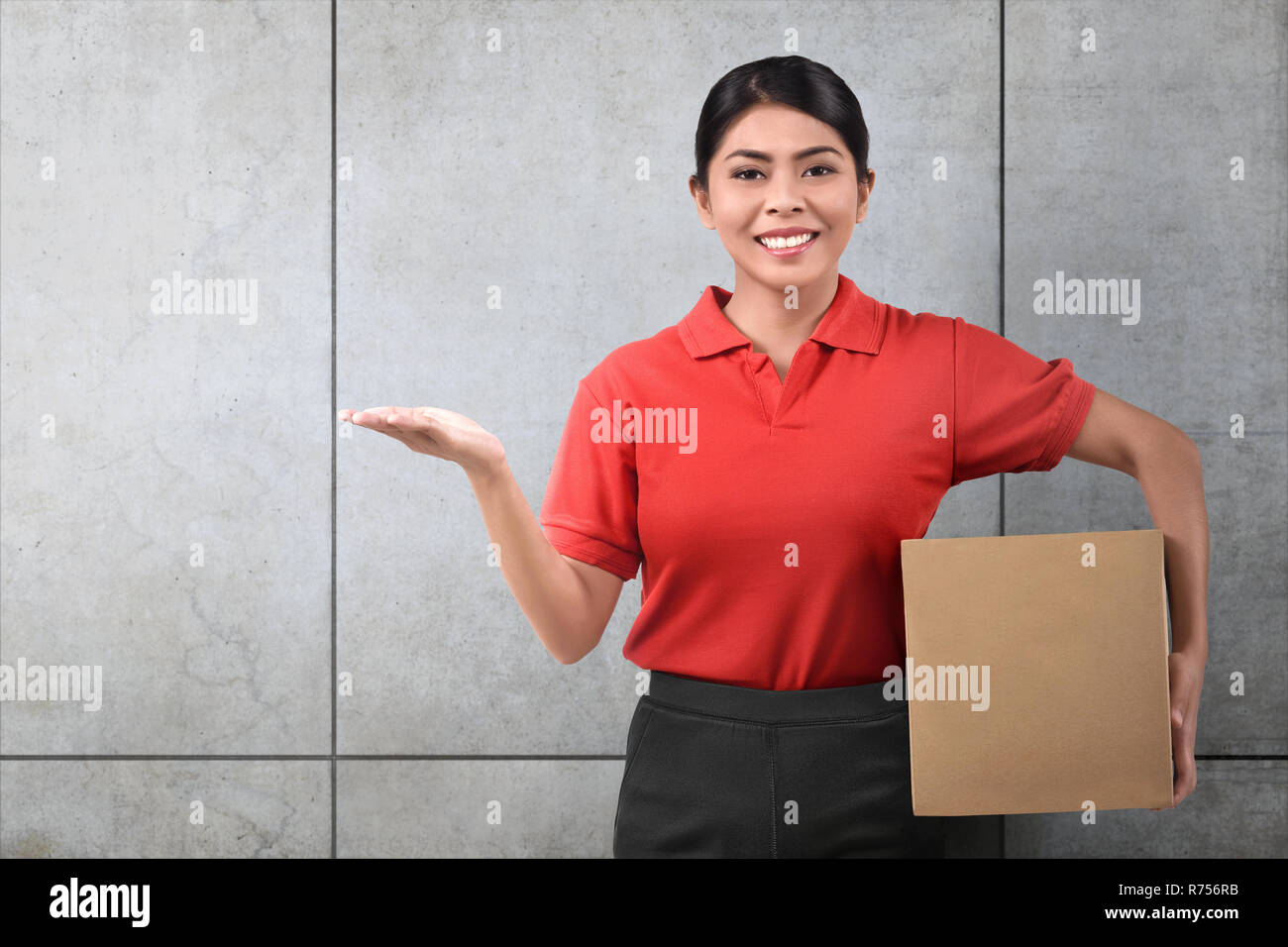 Lächelnd asiatischen Lieferung Frau mit Paket Stockfoto