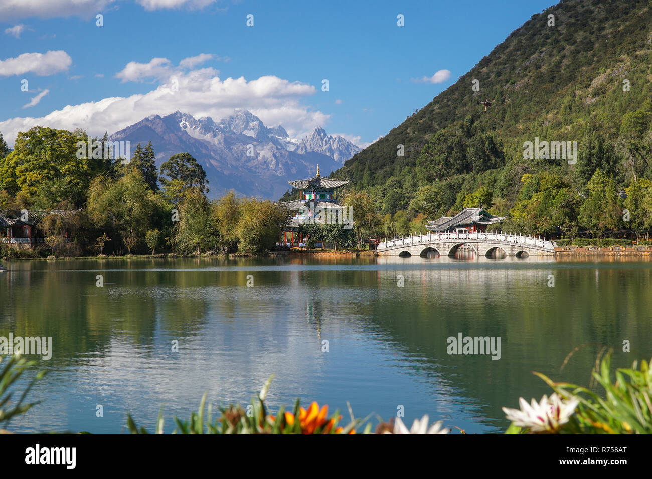 Jade Dragon Snow Mountain und die Suocui Brücke über den Pool des Schwarzen Drachens im Jade Spring Park, Lijiang, Provinz Yunnan, China. Stockfoto