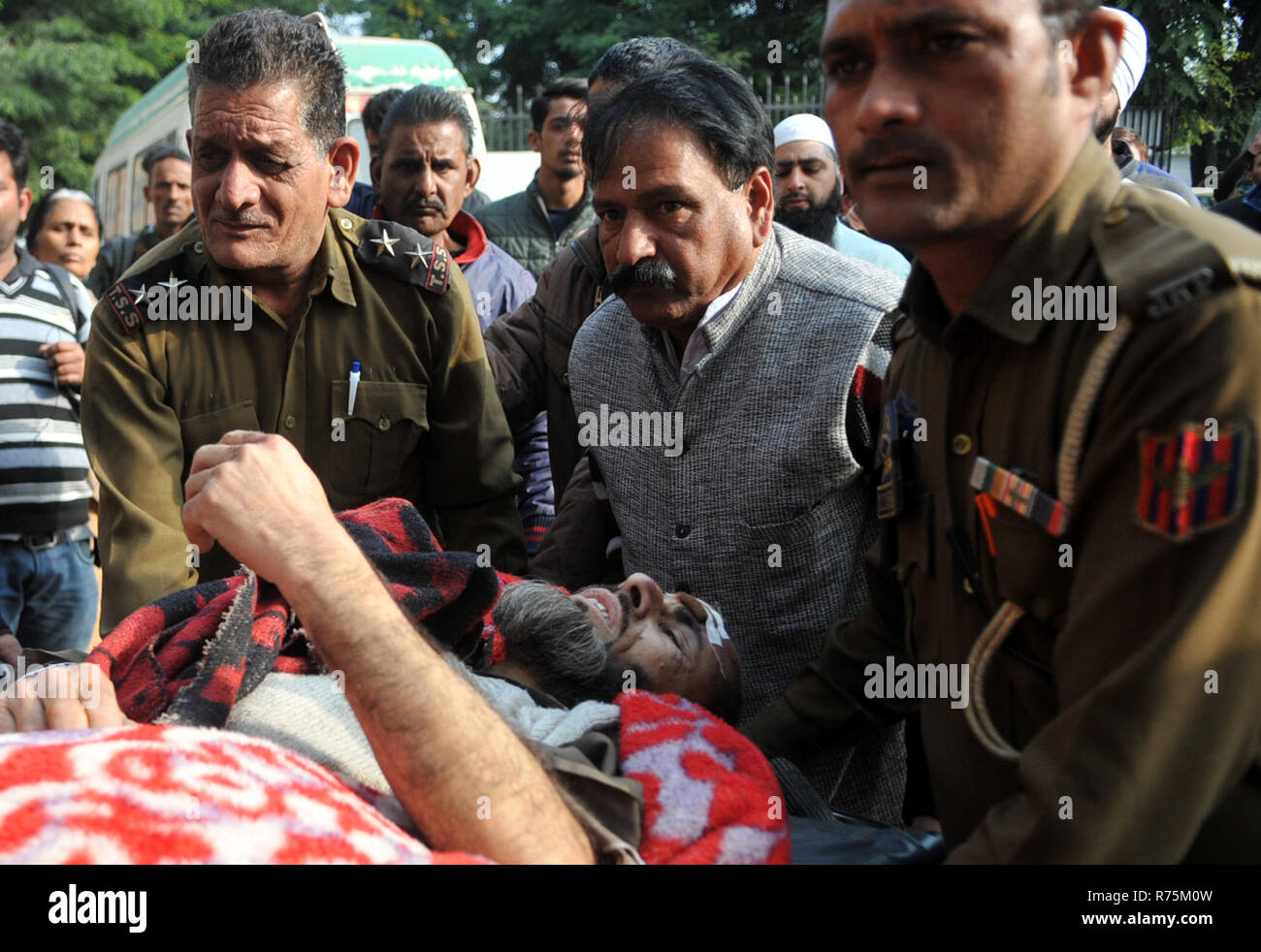 Srinagar, Indisch kontrollierten Teil Kaschmirs. 8 Dez, 2018. Menschen übertragen einen verletzten Mann in ein Krankenhaus nach einem Unfall an Plera in Mandi Tehsil von poonch Bezirk nahm, etwa 210 km südlich von Srinagar Stadt, die Hauptstadt des Indischen-kontrollierten Kaschmir, Dez. 8, 2018. Mindestens 11 Menschen wurden getötet und 19 weitere verletzt Samstag nach einem Bus trug sie aus Rutschte eine bergige Straßen- und fiel in eine Schlucht im indischen Teil Kaschmirs gesteuert. Credit: Stringer/Xinhua/Alamy leben Nachrichten Stockfoto