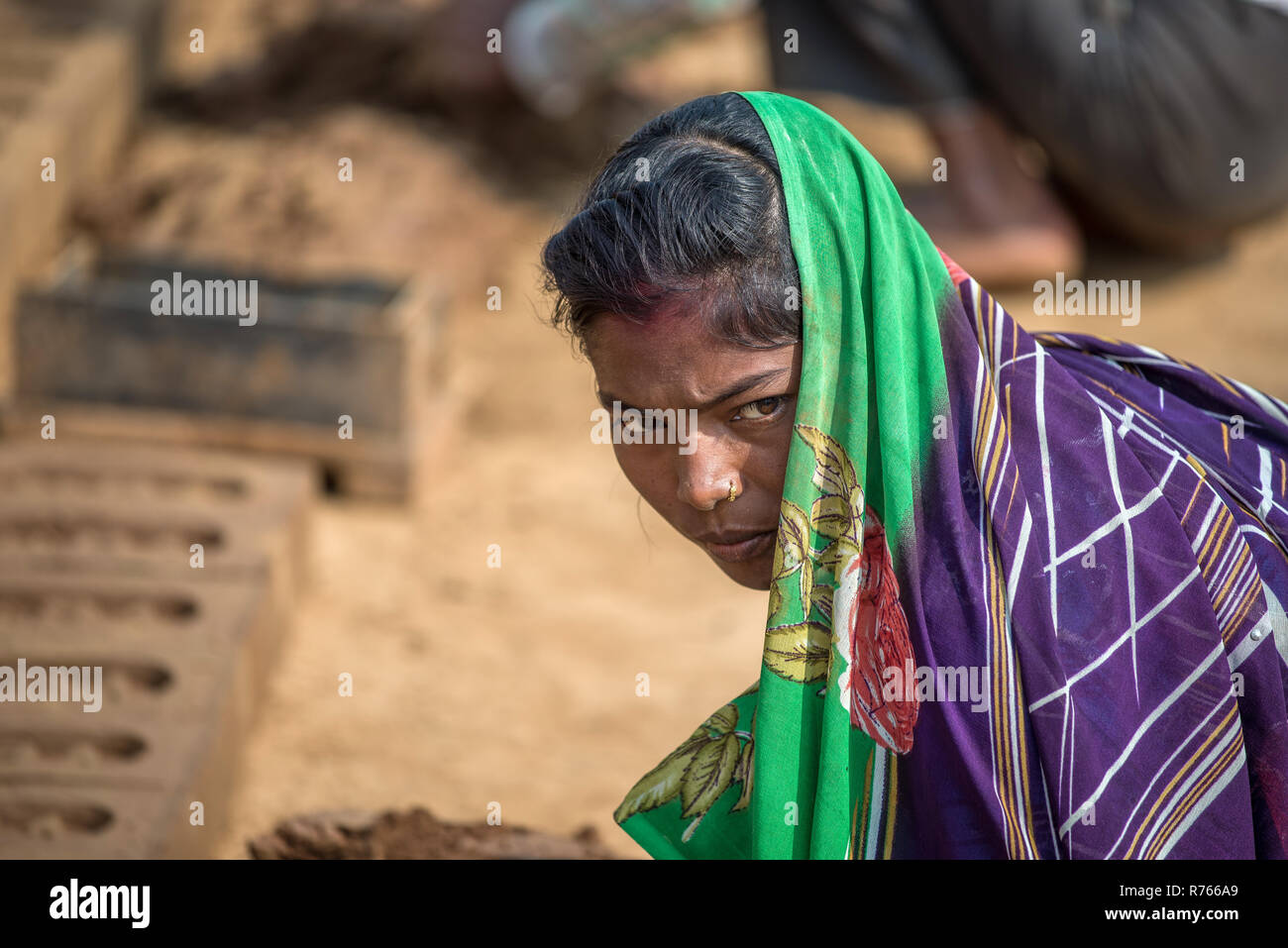 Ein woma mit einem bunten Sari gekleidet arbeitet in einer Ziegelfabrik, Rajasthan, Indien Stockfoto