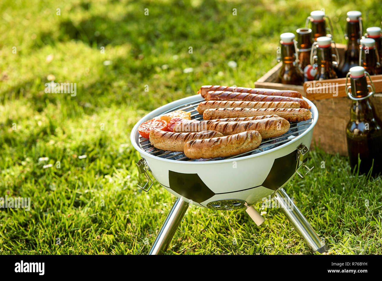 Würstchen grillen auf einen tragbaren Grill im Freien Stockfoto