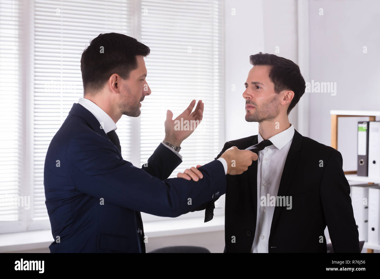 Wütend Geschäftsmann Holding seines Partners Binden Stockfoto