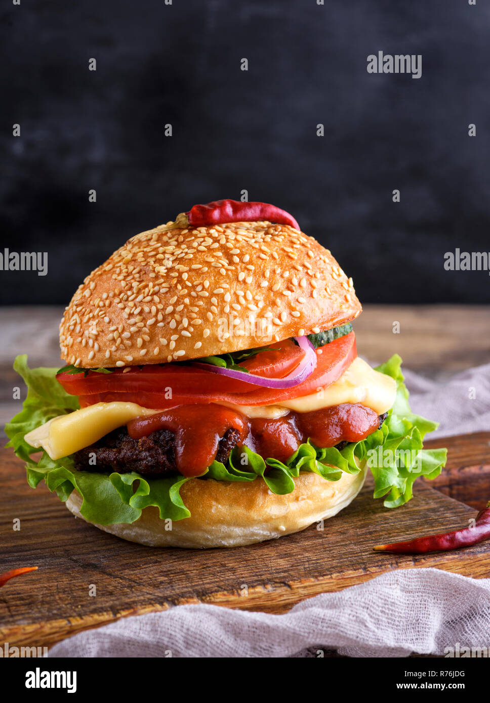 Frische, hausgemachte Burger mit Salat, Käse, Zwiebeln und Tomaten Stockfoto