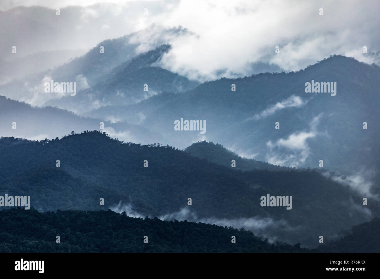 Dark Blue Mountain Range in verschiedenen Schichten der Winter von Nebel und Wolken bedeckt nach Lampang, Thailand regnet. Stockfoto