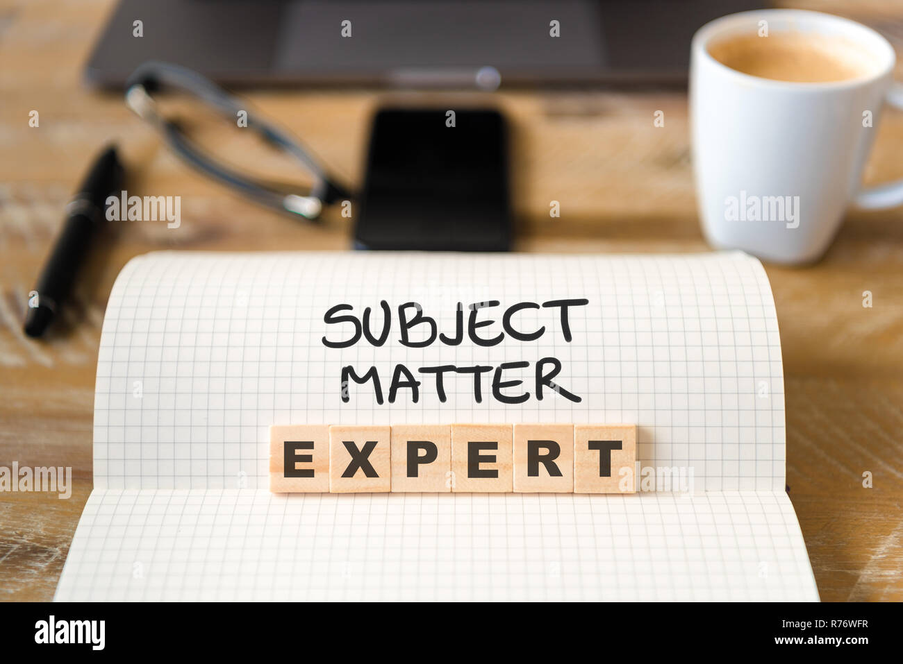 Nahaufnahme auf das Notebook um Vintage Schreibtisch Hintergrund, der Schwerpunkt auf Holzblöcke mit Buchstaben, Experte text Stockfoto