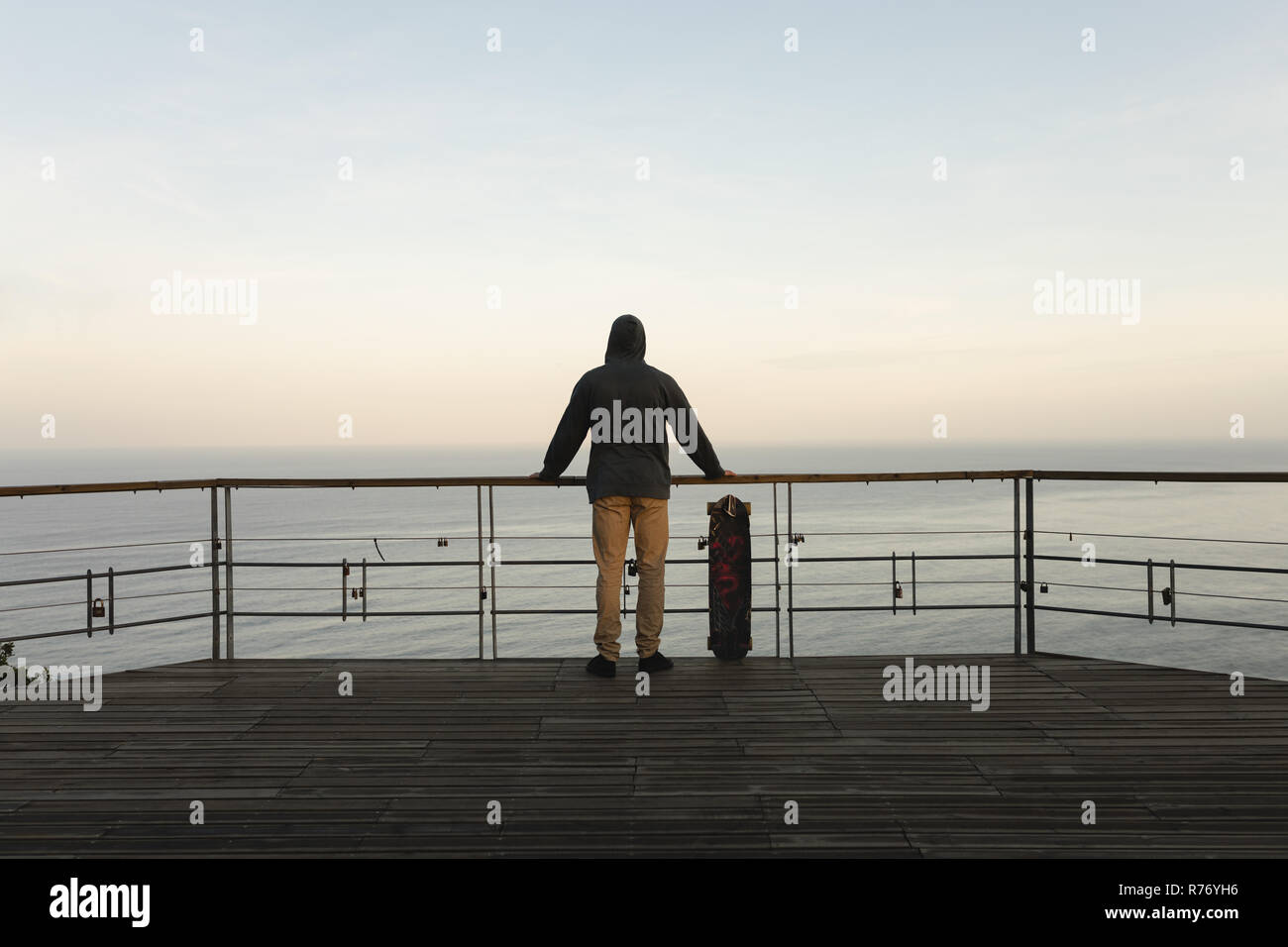 Männliche skateboarder stehen durch Geländer am Aussichtspunkt Stockfoto