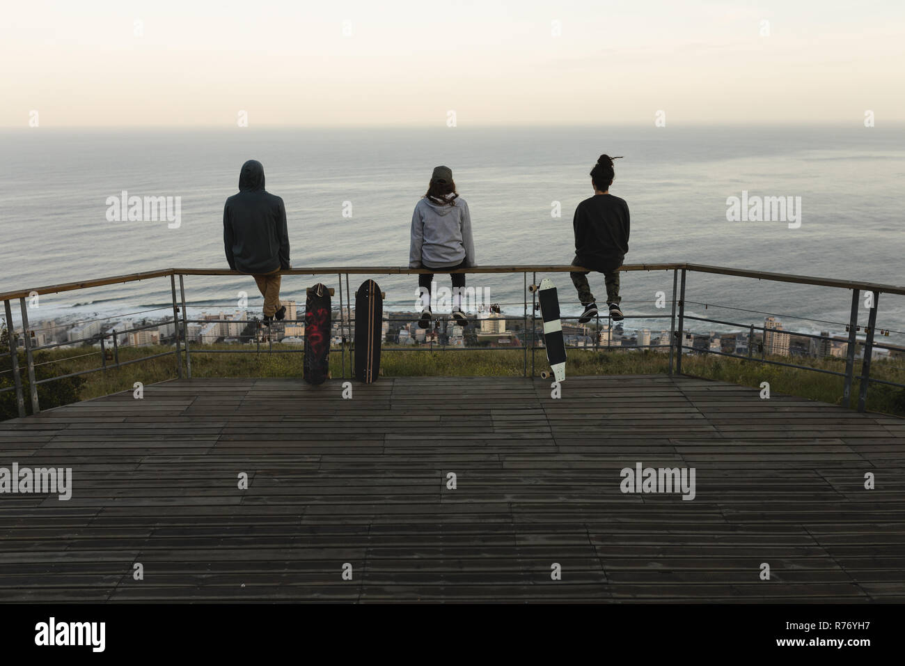 Skateboarder auf Geländer am Beobachtungspunkt sitzen Stockfoto