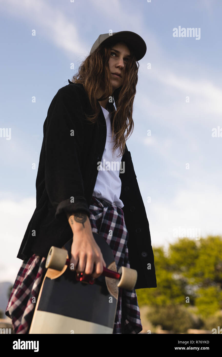 Weiblichen skateboarder stehend mit Skateboard Stockfoto