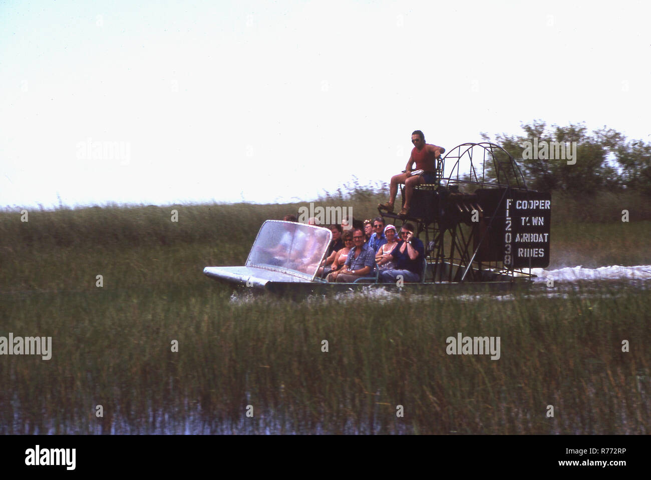 1970 s, Touristen, die auf einem Airboat in den Florida Everglades, ein Bereich der tropischen Feuchtgebiete in den USA. Die flachen Design der airboat ermöglicht eine einfache Navigation durch flachen Mooren und Sümpfen. Ökotourismus Airboating ist eine beliebte Attraktion. Coopertown Luftbootfahrten ist eine touristische Attraktion im Jahr 1945 gegründet. Stockfoto