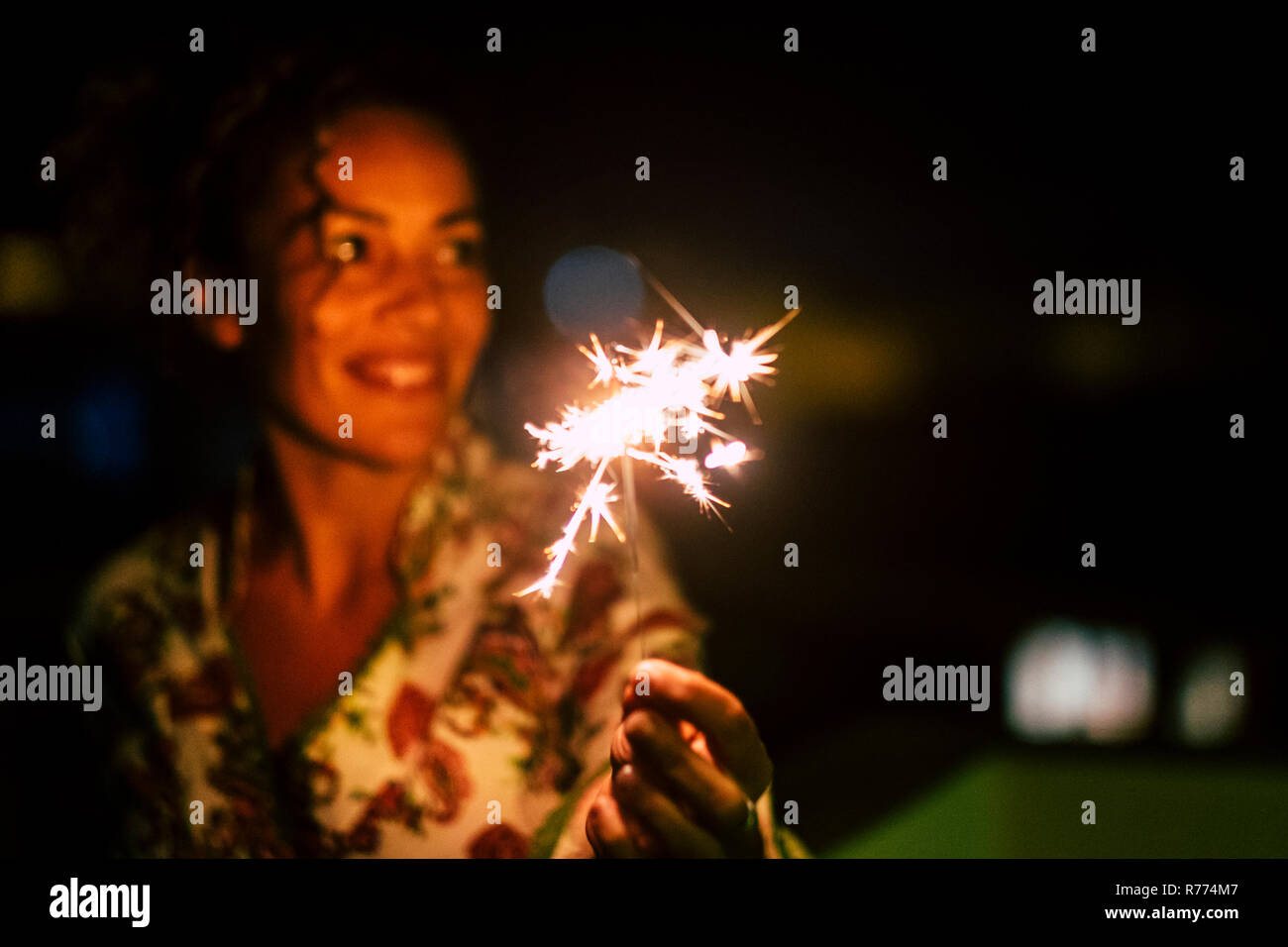 Schöne kaukasische Frau feiern mit funkelt das Licht durch die Nacht - Fokus auf Feuer - Feuerwerk für Silvester oder Geburtstagsfeier Konzept-Peop Stockfoto