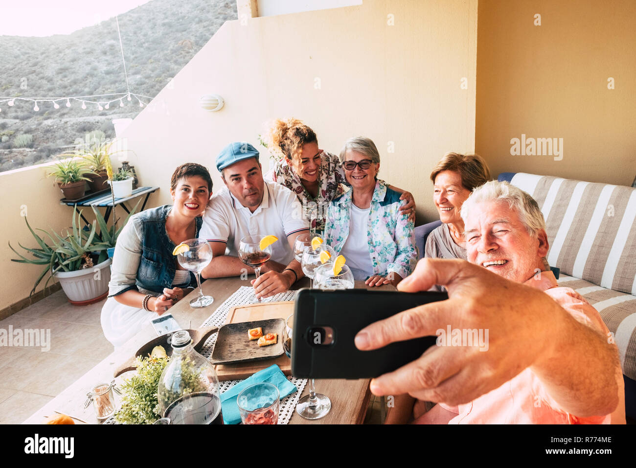 Gruppe der kaukasischen Völker Männer und Frauen feiern gemeinsam zu Hause auf der Terrasse - Christmas Dinner oder Geburtstagsfeier - erwachsenen Mann nehmen ein selfie pictu Stockfoto