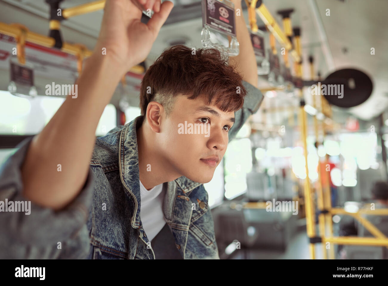 Leute, Lifestyle, Reisen und öffentlichen Verkehrsmitteln. Asiatischer Mann stehend im Stadtbus. Stockfoto