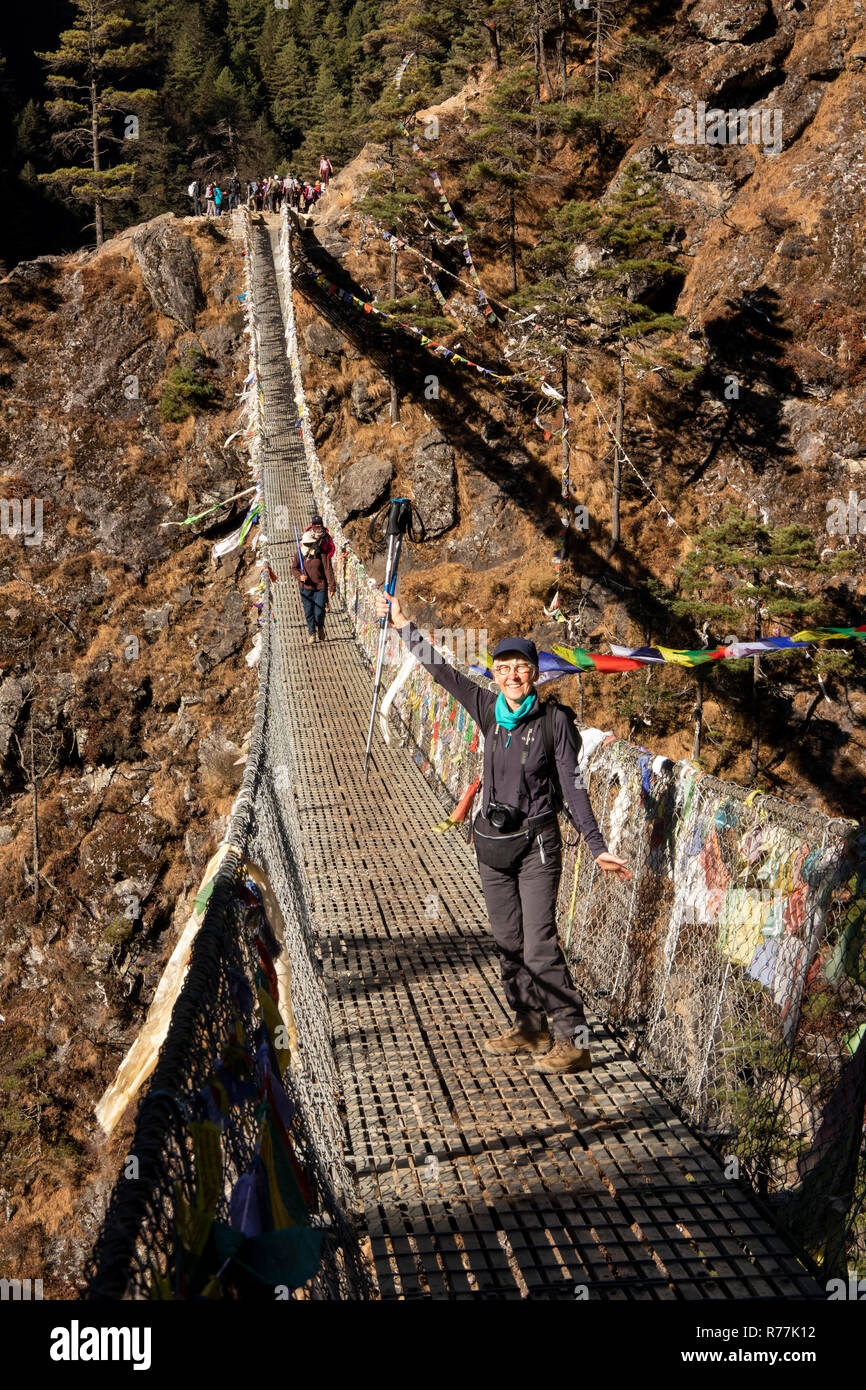 Nepal, Larja Dobhan, Senior weibliche Touristen halten Stöcke feiern Kreuzung Obere Larja Hängebrücke über Dudh Khosi Fluss Stockfoto