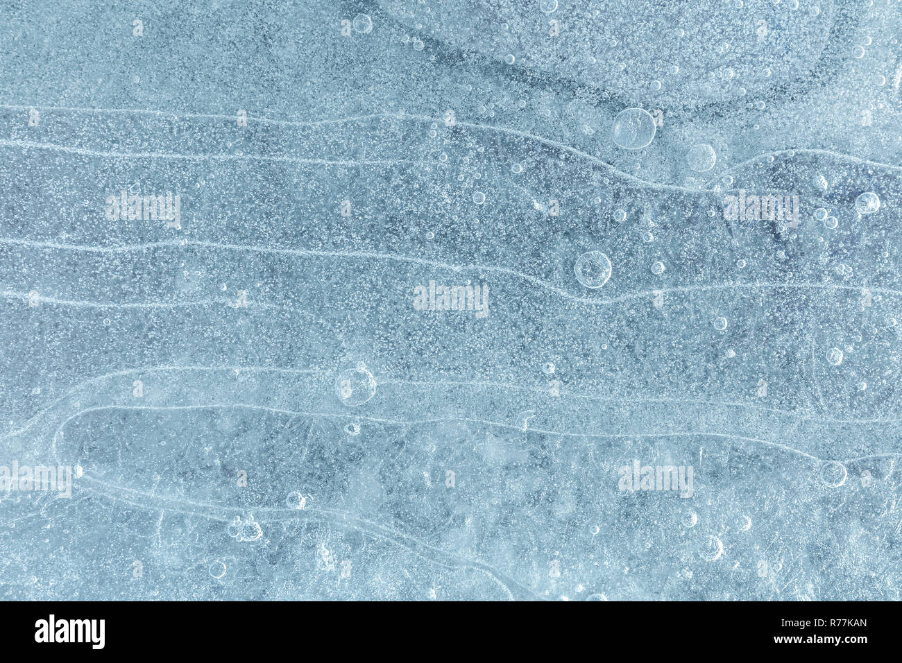 Gefrorene Eisfläche Hintergrund mit Luftblasen geknackt. Kalte eisige Winter Textur Stockfoto