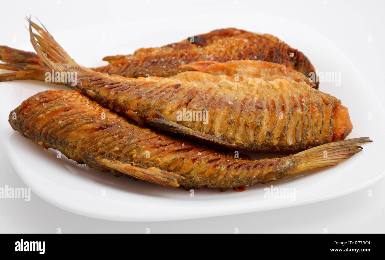 Gebratene Fluss Fisch mit dem Schneiden, zurück. Auf weiße Platte. Stockfoto