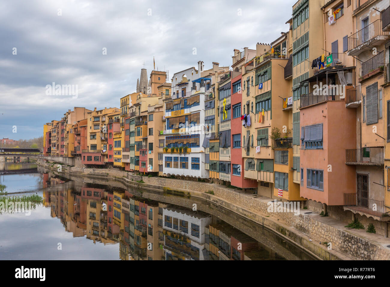 Bunte gelb, rot und orange Häuser mit der katalanischen Flaggen in Wasser Fluss Onyar, in Girona, Katalonien, Spanien wider. Stockfoto