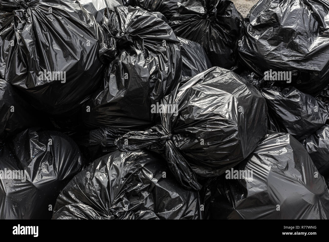 Haufen von schwarzen Abfallbehälter, Kunststoff Müllsack Hintergrund. Stockfoto