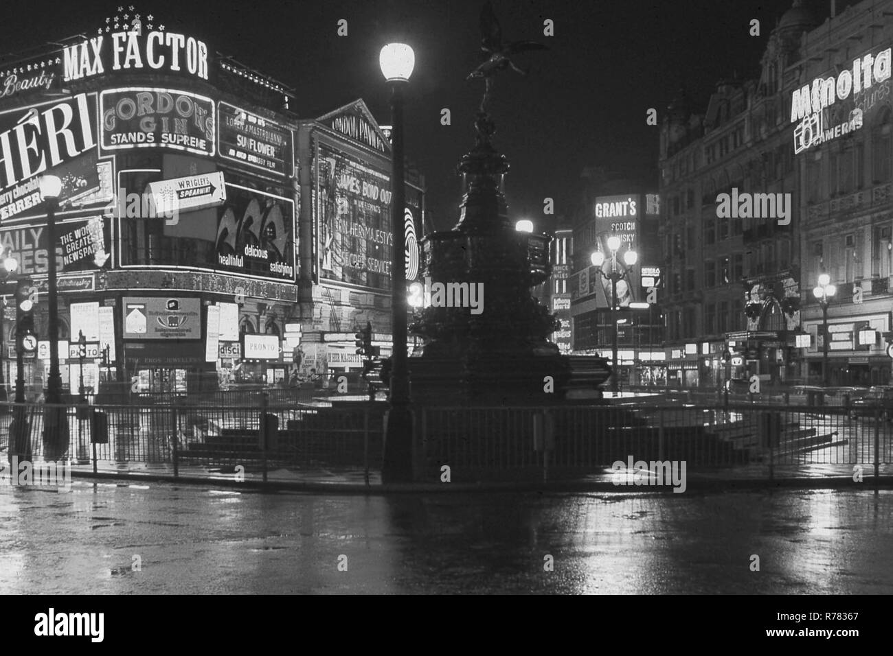 1969, einem feuchten Londoner Nacht, hier gesehen ist das Shaftesbury Memorial Fountain, besser bekannt als Statue von Eros am Piccadilly Circus genannt, mit den Neonlichtern der umliegenden Werbetafeln. Übersicht an der London Pavilion, der neue James Bond Film "Im Geheimdienst Ihrer Majestät", der sechste Film der Bond 007-Serie. Stockfoto